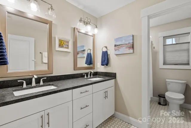 a bathroom with a granite countertop sink mirror and toilet