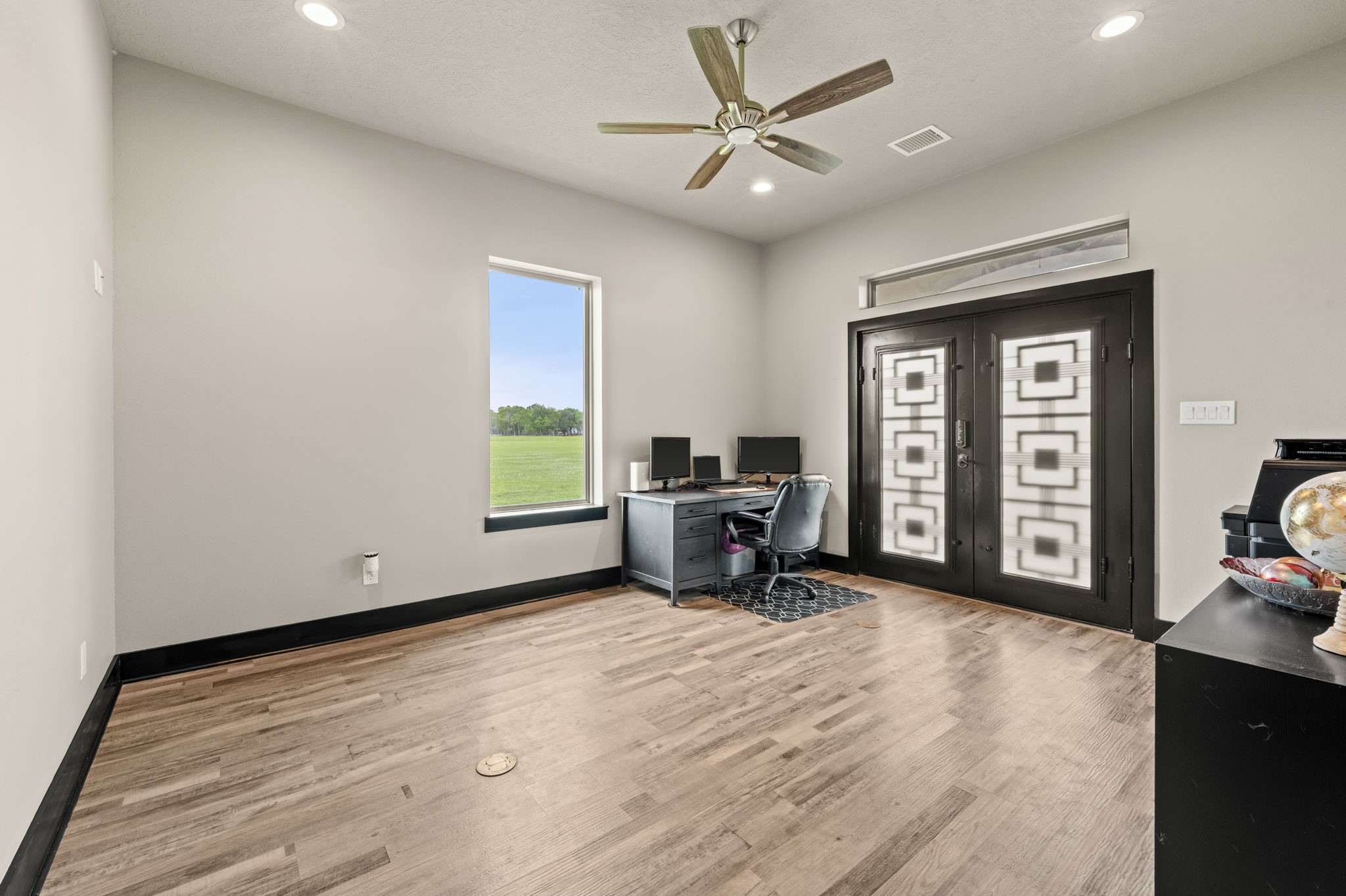 2856 Wolcek Road Crosby, TX 77532 - Photo 23 of 48 This room features a modern home office/flex room/bedroom setup with sleek engineered floors, a large window offering plenty of natural light, and stylish double doors. Ideal for remote work, study or whatever your heart desires. It combines functionality with contemporary design.
