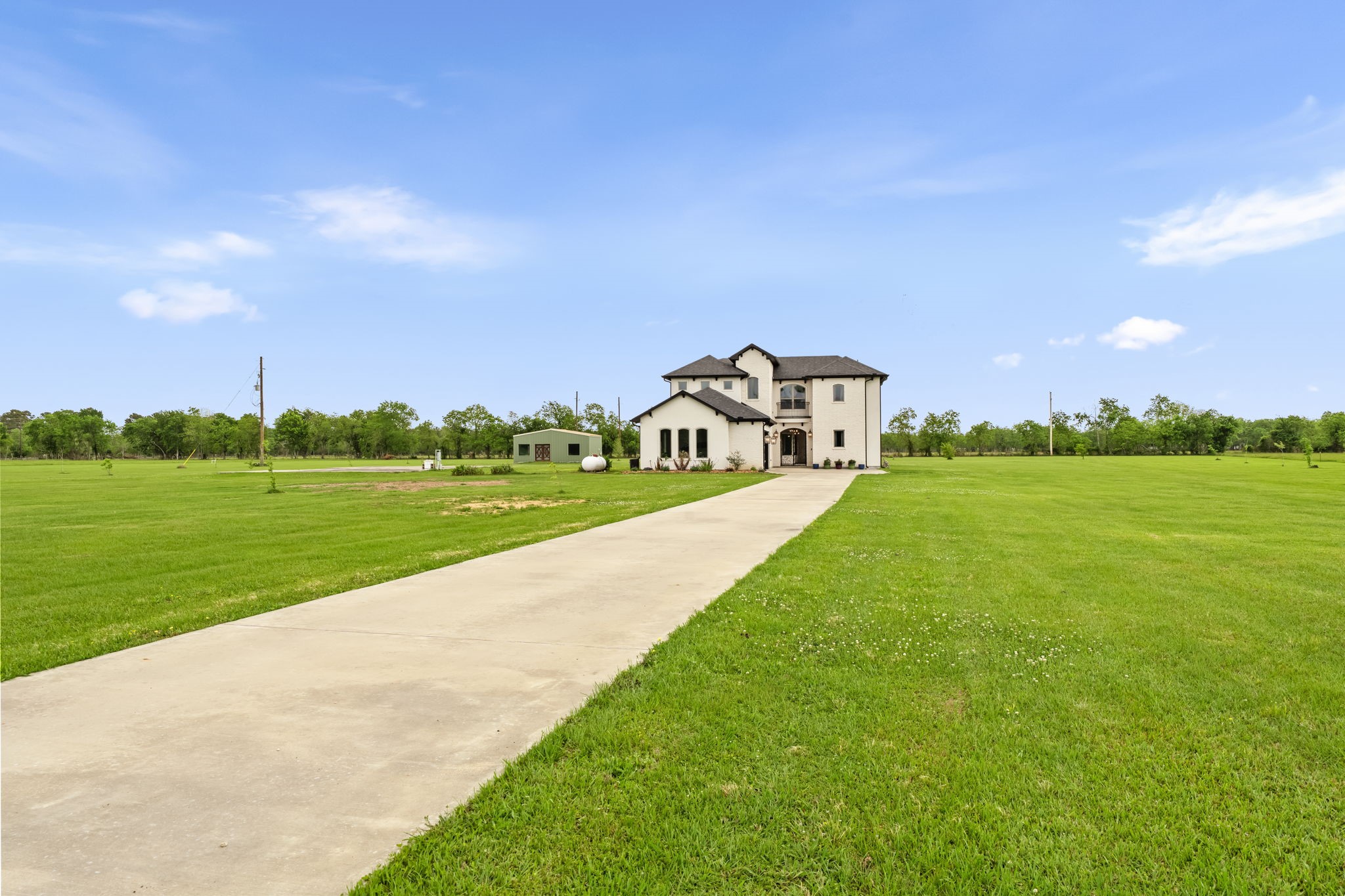 2856 Wolcek Road Crosby, TX 77532 - Photo 47 of 48 Gorgeous spacious home on a large green 7 acre lot with a long driveway, surrounded by open land and a few trees under a clear blue sky. Absolute heaven!