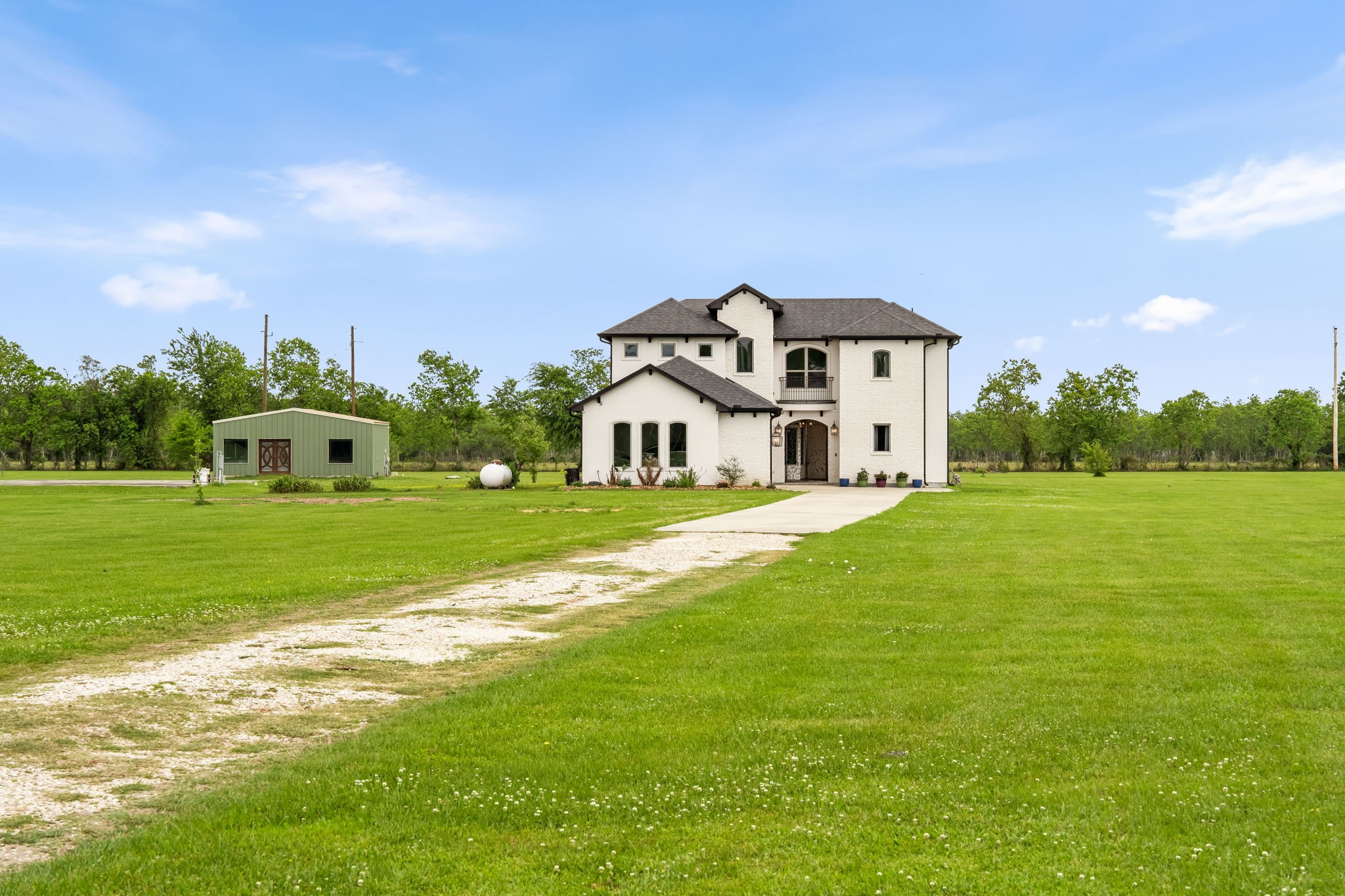 2856 Wolcek Road Crosby, TX 77532 - Photo 48 of 48 Next to the two-story home, there's a separate green outbuilding in the background that is an unfinished apartment. The seller has the original building plans, which include a kitchen, open area/ bedroom area, bathroom and a closet. It is prewired and plumbed. It is currently being used as storage but, could be a cool teenager hangout, pool house, guest house, ADU, gym or a very private office. The options are unlimited.