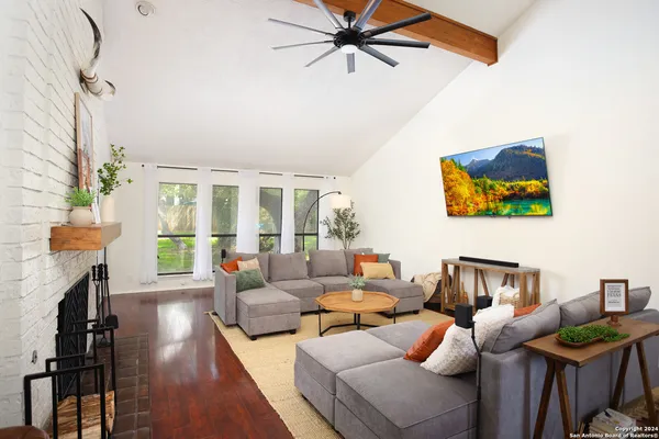a living room with furniture a fireplace and a floor to ceiling window