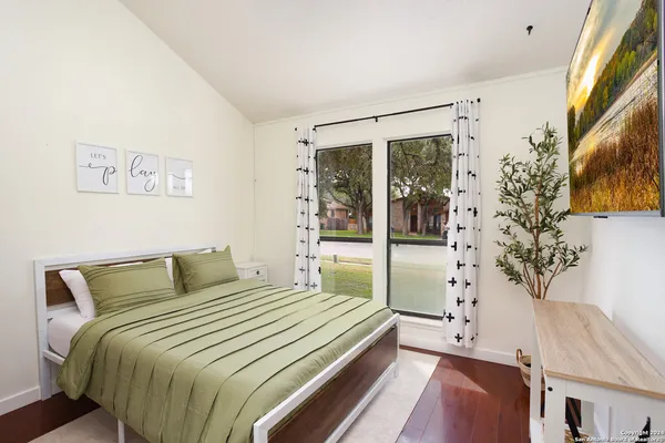 a bedroom with a large bed and a potted plant