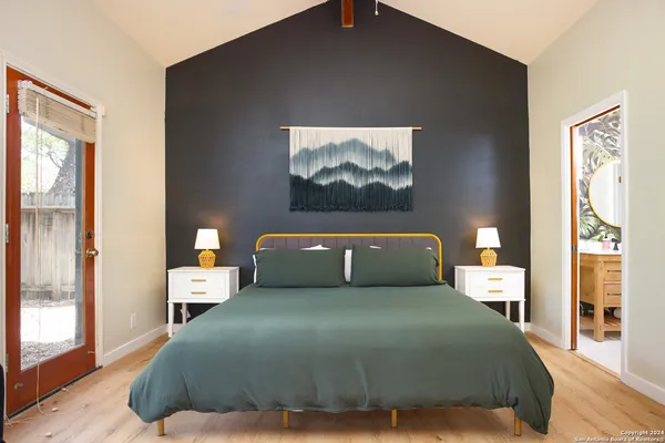 a bedroom with a bed and wooden floor