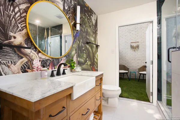 a bathroom with a sink a toilet and a mirror