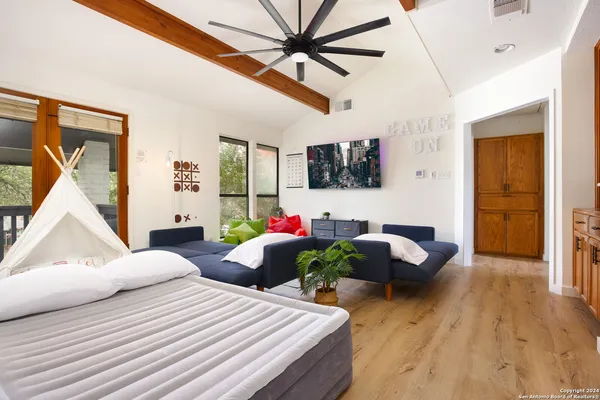 a bedroom with a bed a couch and a flat screen tv