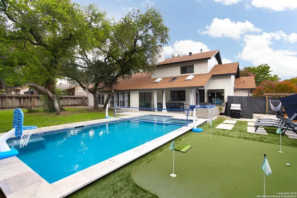 a view of a house with swimming pool and sitting area