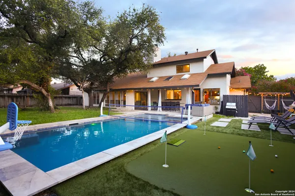 an aerial view of a house with swimming pool garden view and trees
