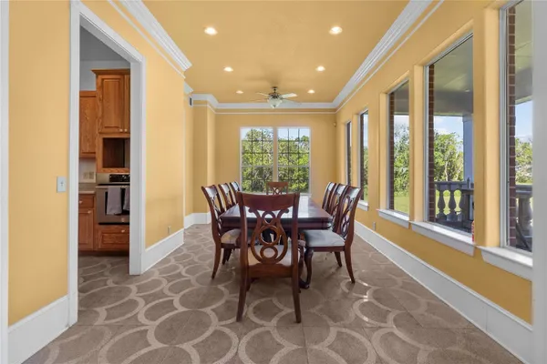 a dining room with furniture and large windows