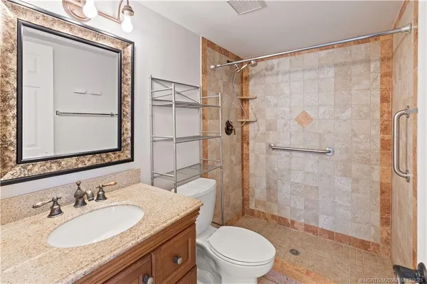 an empty room with chandelier fan and closet area