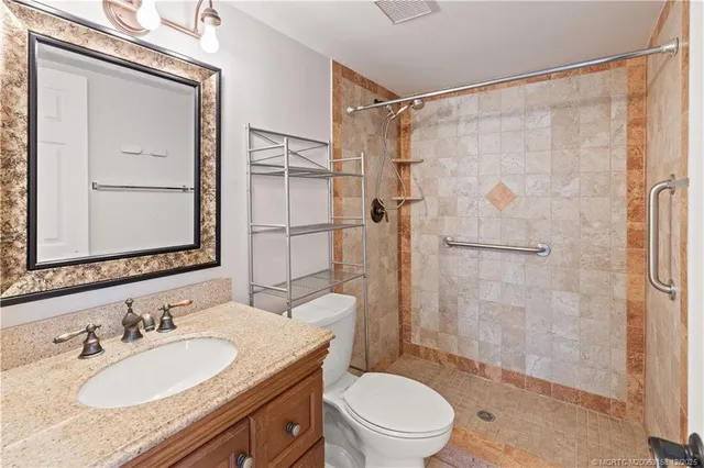 an empty room with chandelier fan and closet area