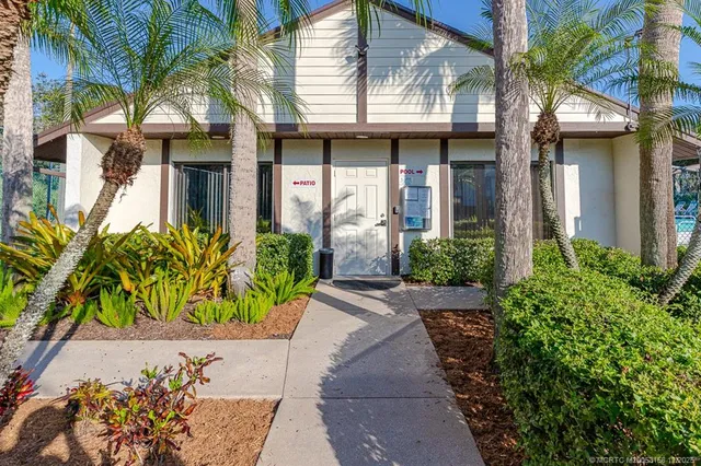 a view of a patio with a table and chairs under an umbrella