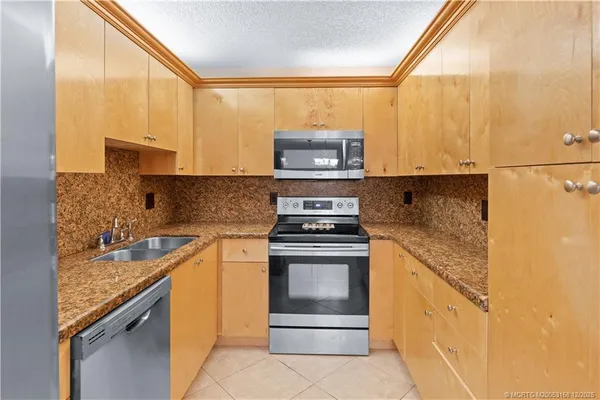 a kitchen with stainless steel appliances granite countertop a refrigerator and a sink