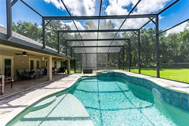 a swimming pool with outdoor seating and yard