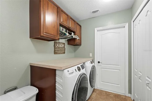 an aerial view of a house with swimming pool and large trees
