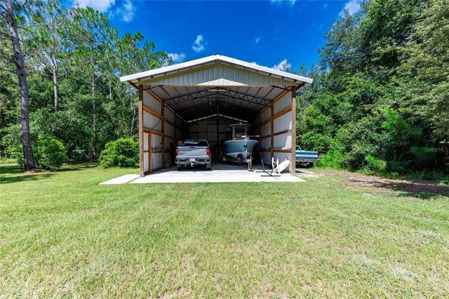 a view of a house with a yard and basketball court