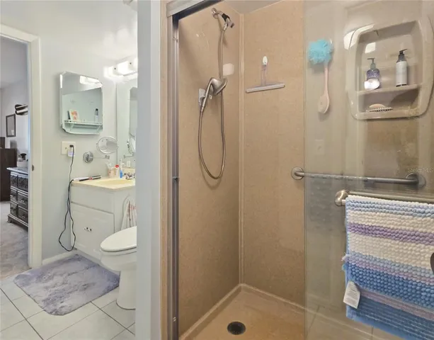a bathroom with a granite countertop sink a toilet and shower