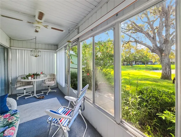 a living room with patio furniture and a floor to ceiling window