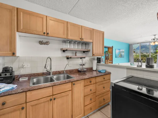 a kitchen with stainless steel appliances granite countertop a sink a stove and cabinets