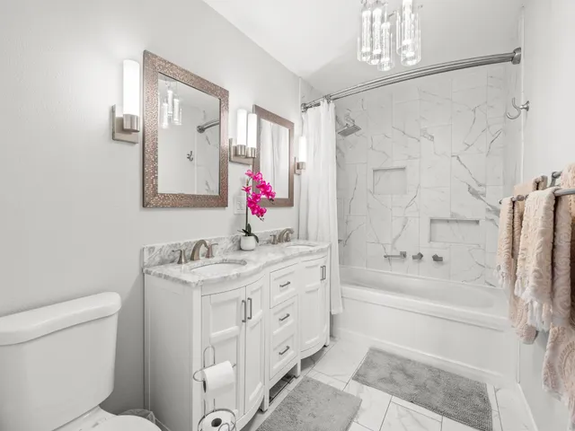 a bathroom with a granite countertop sink a mirror a toilet and a bathtub