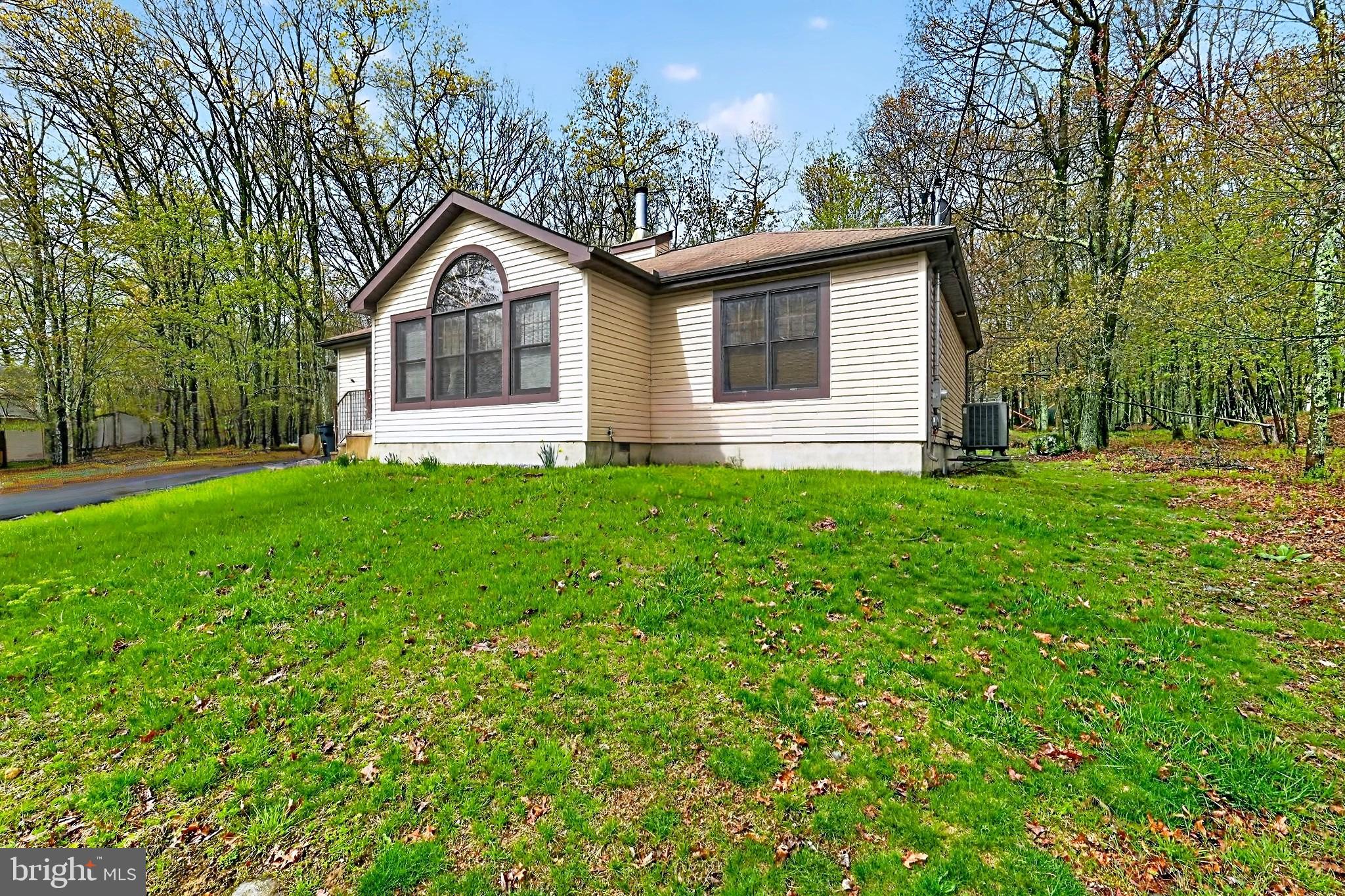 4341 Pine Ridge Drive East Bushkill, PA 18324 - Photo 2 of 19 a front view of a house with a yard and trees