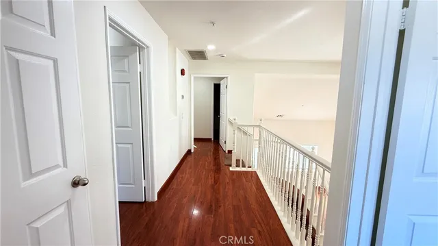 a view of a hallway with wooden floor and staircase