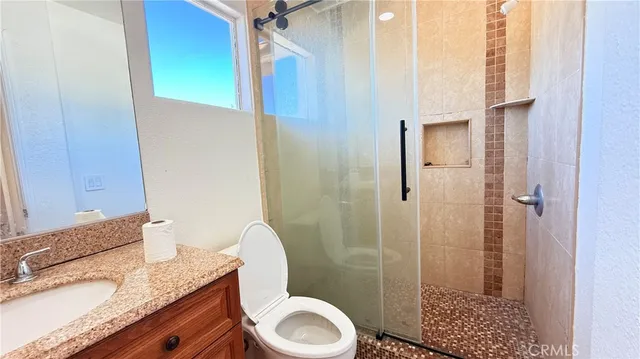 a bathroom with a granite countertop sink toilet and shower