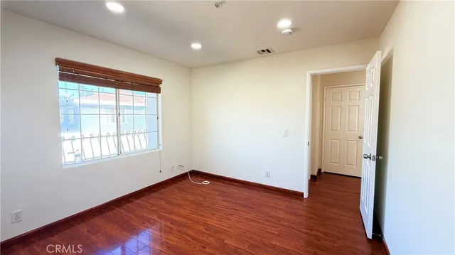 an empty room with wooden floor and a window