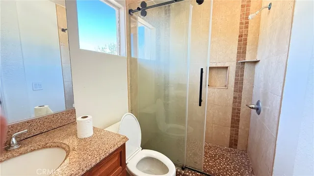 a bathroom with a granite countertop sink toilet and shower