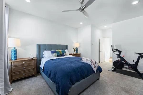 a spacious bedroom with a bed and a chandelier