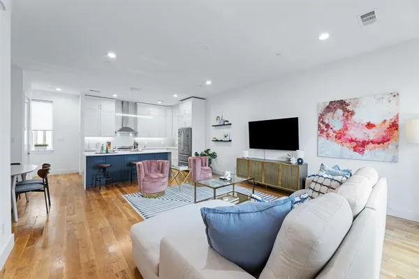 a living room with furniture wooden floor and a flat screen tv