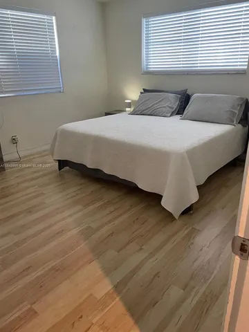 a view of a room with wooden floor and windows