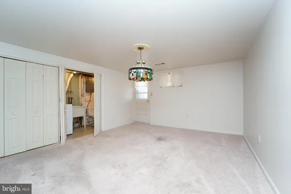 an empty room with closet and mirror