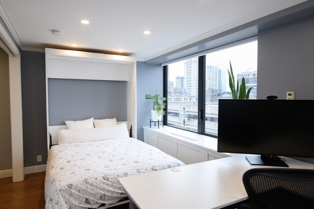 65 East India Row, Unit 9C Boston, MA 02110 - Photo 16 of 40 a bedroom with a bed and glass window