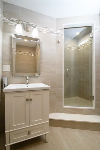 a bathroom with a sink a mirror and a shower