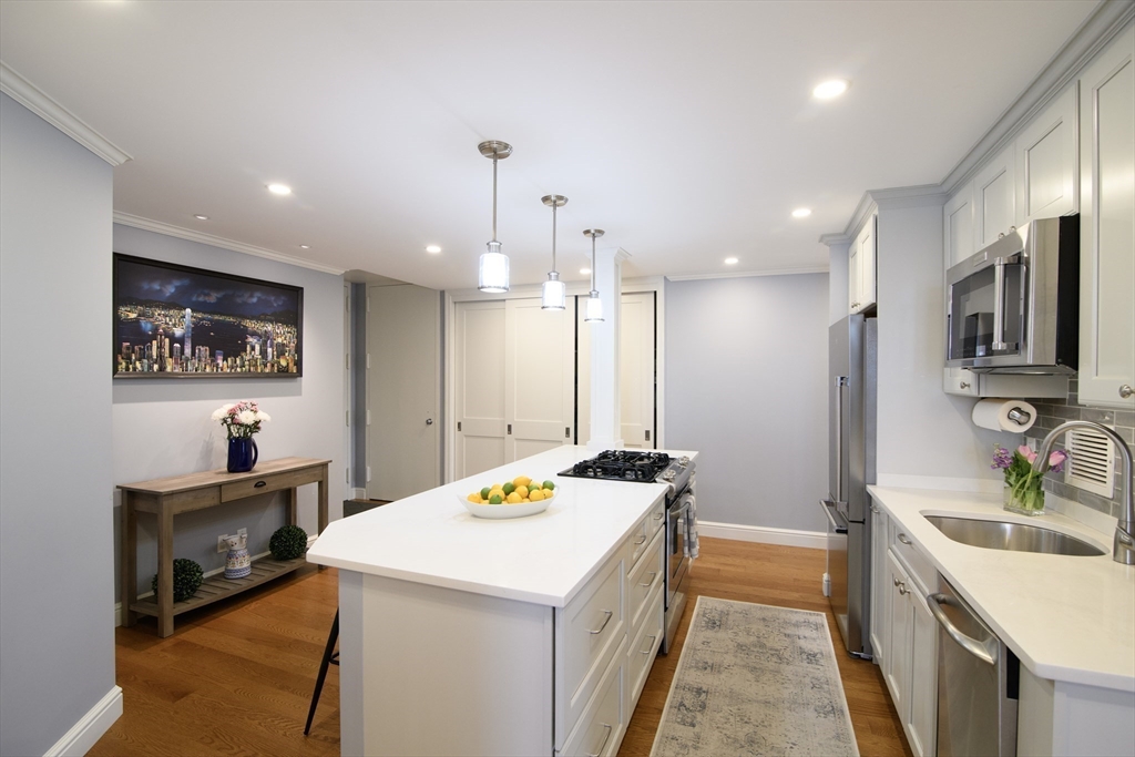 65 East India Row, Unit 9C Boston, MA 02110 - Photo 2 of 40 a kitchen that has a lot of cabinets and wooden floor