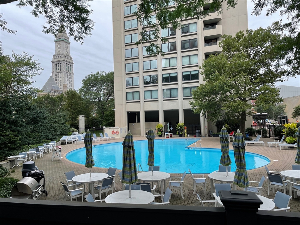65 East India Row, Unit 9C Boston, MA 02110 - Photo 32 of 40 a view of a patio with table and chairs potted plants and palm tree