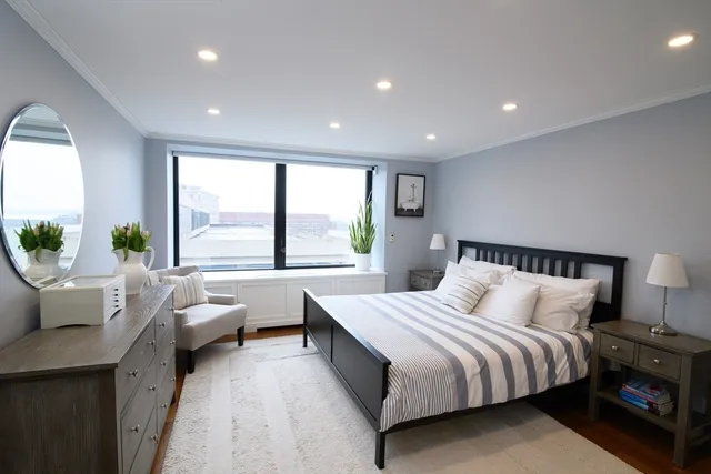 a bedroom with a bed and a large window