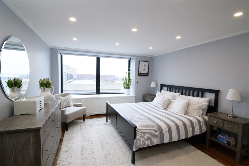 65 East India Row, Unit 9C Boston, MA 02110 - Photo 4 of 40 a bedroom with a bed and a large window