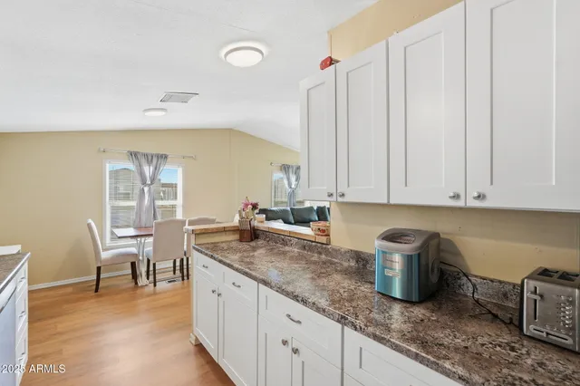 a kitchen with stainless steel appliances granite countertop a refrigerator a stove and a sink with wooden floor
