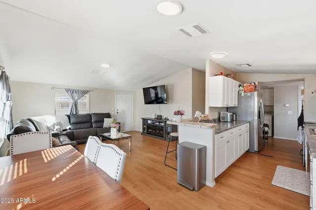 a kitchen with granite countertop a sink white cabinets and white appliances