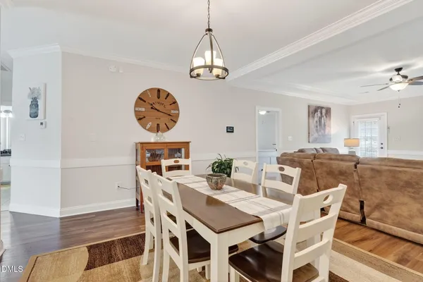 a kitchen with stainless steel appliances granite countertop a refrigerator a sink dishwasher a stove and white cabinets with wooden floor