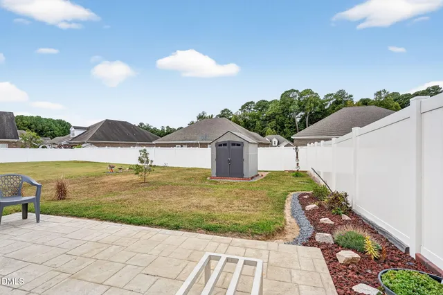 a view of an house with backyard and sitting area