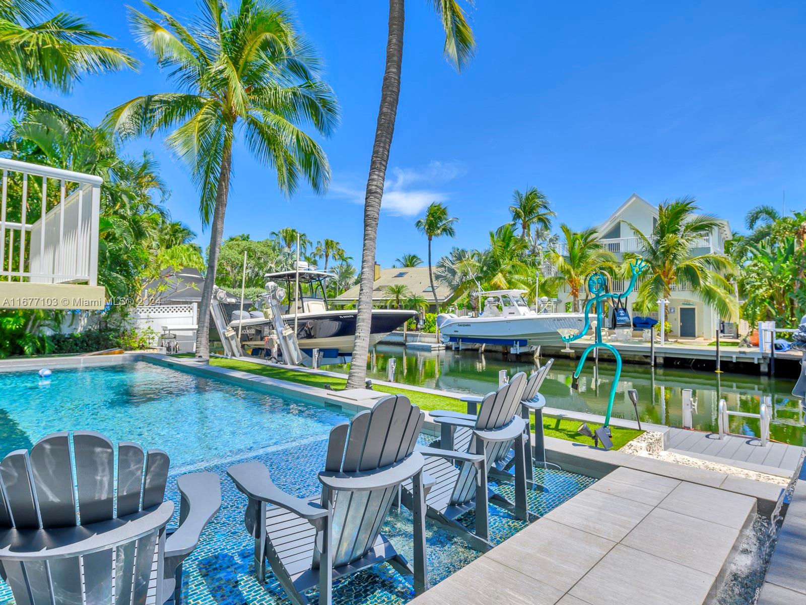 3 North Drive Key Largo, FL 33037 - Photo 11 of 54 a view of a swimming pool with a table and chairs