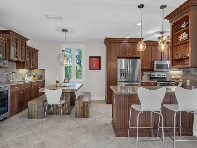 a kitchen with granite countertop stainless steel appliances a refrigerator and a sink