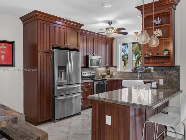 a kitchen with stainless steel appliances granite countertop a refrigerator and a sink