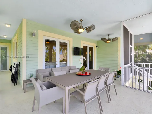 a view of a porch with chairs and floor to ceiling window
