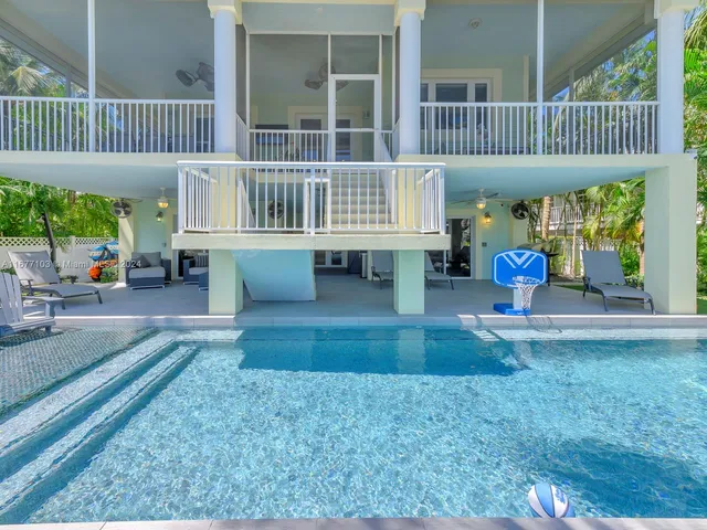 a view of a livingroom with wooden floor and a bathroom