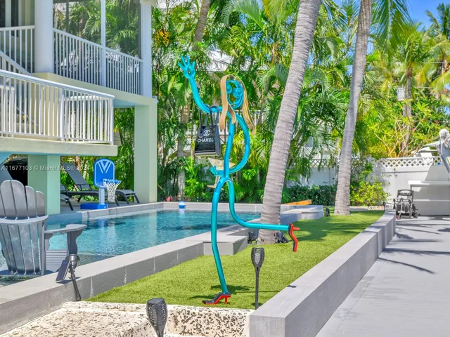 a view of swimming pool with lawn chairs and plants