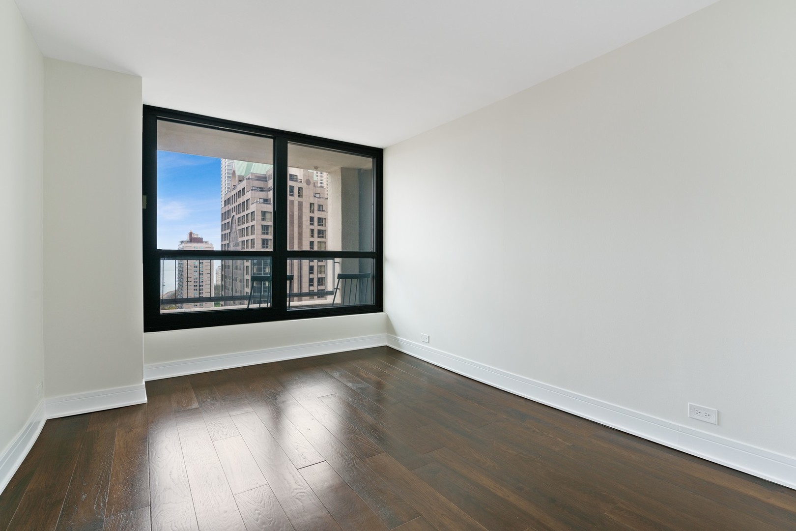 1030 North State Street, Unit 13E Chicago, IL 60610 - Photo 15 of 30 a view of an empty room with wooden floor and a window