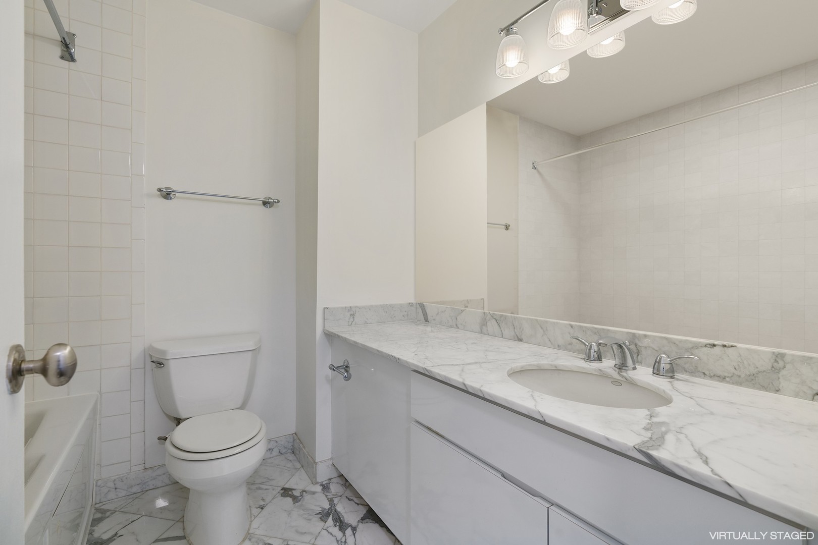 1030 North State Street, Unit 13E Chicago, IL 60610 - Photo 18 of 30 a bathroom with a granite countertop toilet sink and mirror